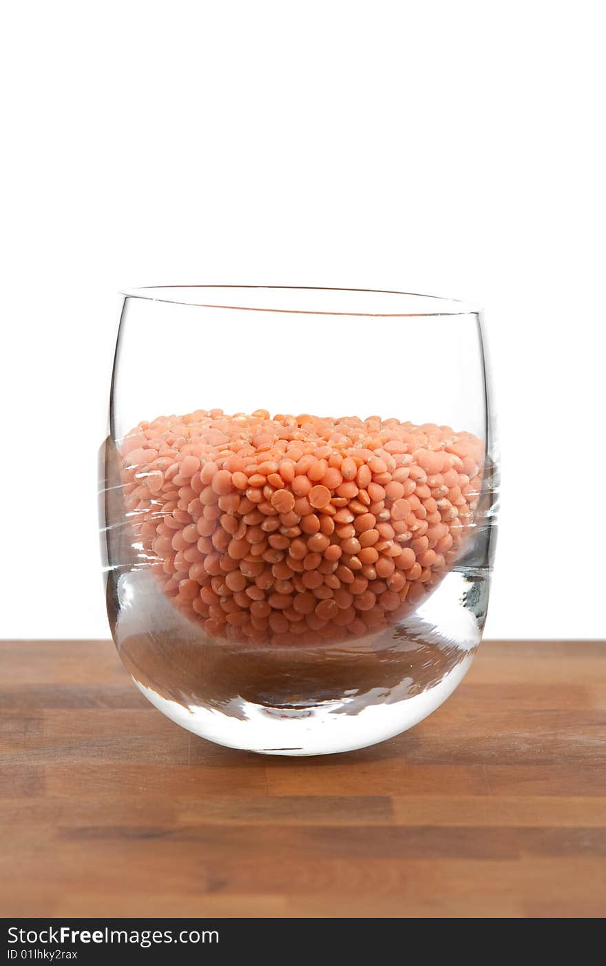 Red Lentils In Glass On Wooden Table