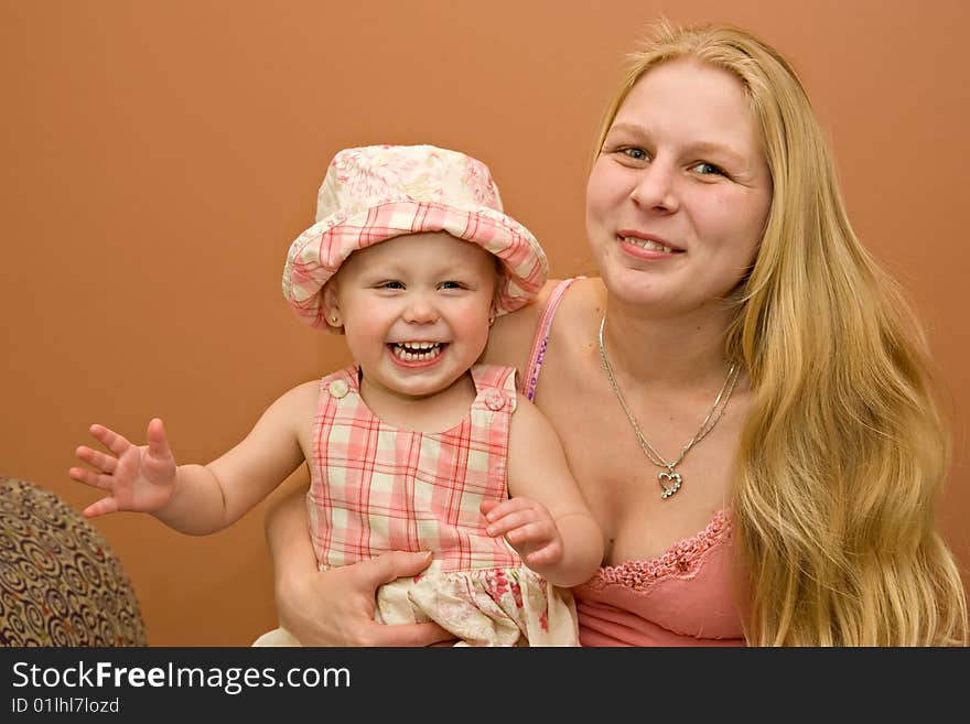 Young beautiful blond blue-eyed mother and daughter smiling portrait. Young beautiful blond blue-eyed mother and daughter smiling portrait