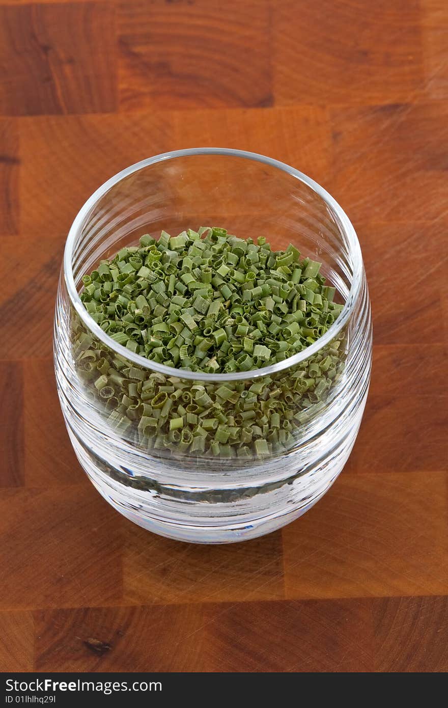 Dried chive in glass on wooden table