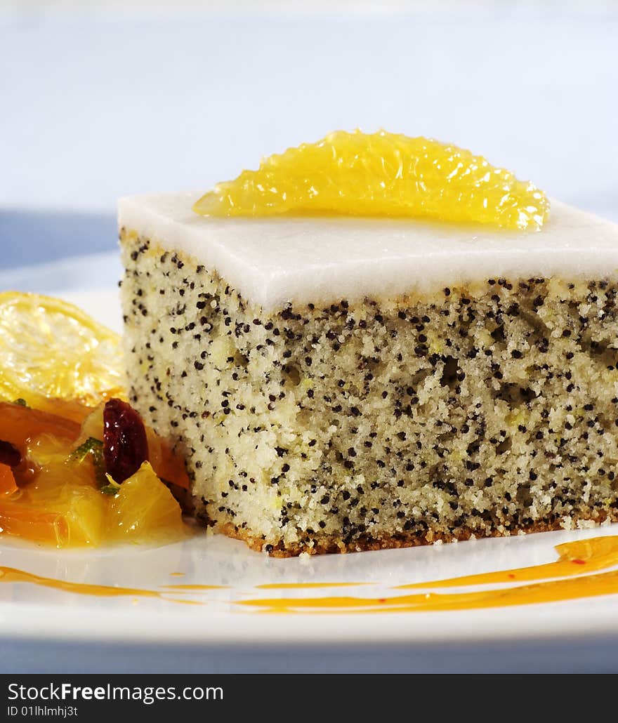 Puff poppyseed cake with sugar icing served with fruit. Puff poppyseed cake with sugar icing served with fruit