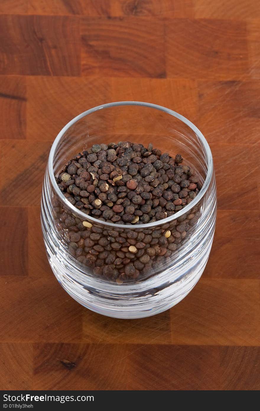 Green lentils in glass on wooden table