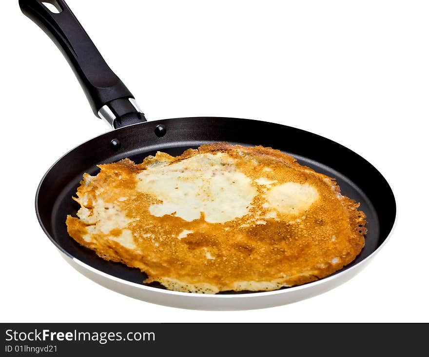 Pancake cooking in a pan isolated on white