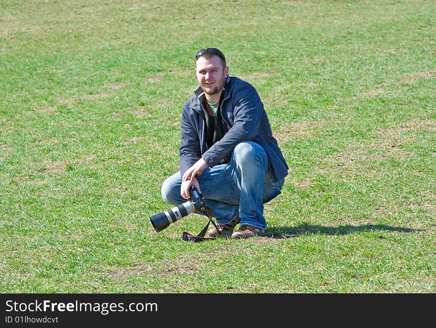 Man on meadow with camera. Man on meadow with camera