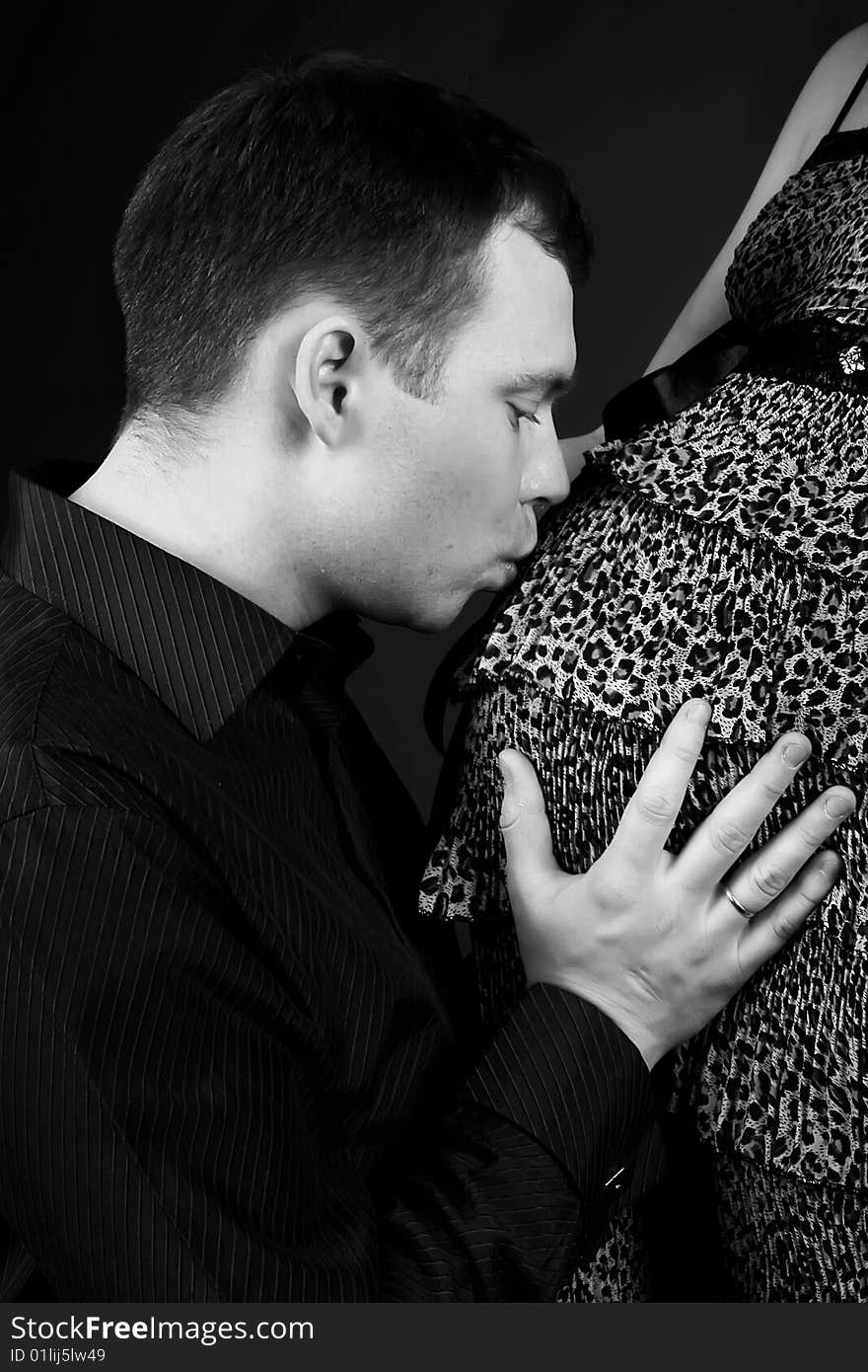 Young beautiful married couple the birth of the second child wait. Pink background. New photos every week