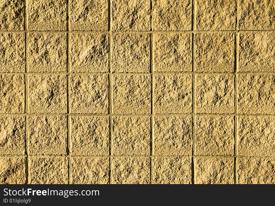 A stone wall is texture to look like rough tiles in the sun. A stone wall is texture to look like rough tiles in the sun.