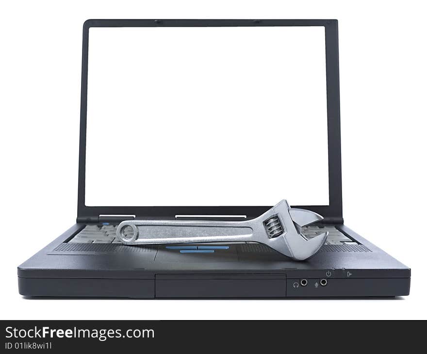 A spanner over a black laptop isolated over white background. White copy space on screen. A spanner over a black laptop isolated over white background. White copy space on screen.