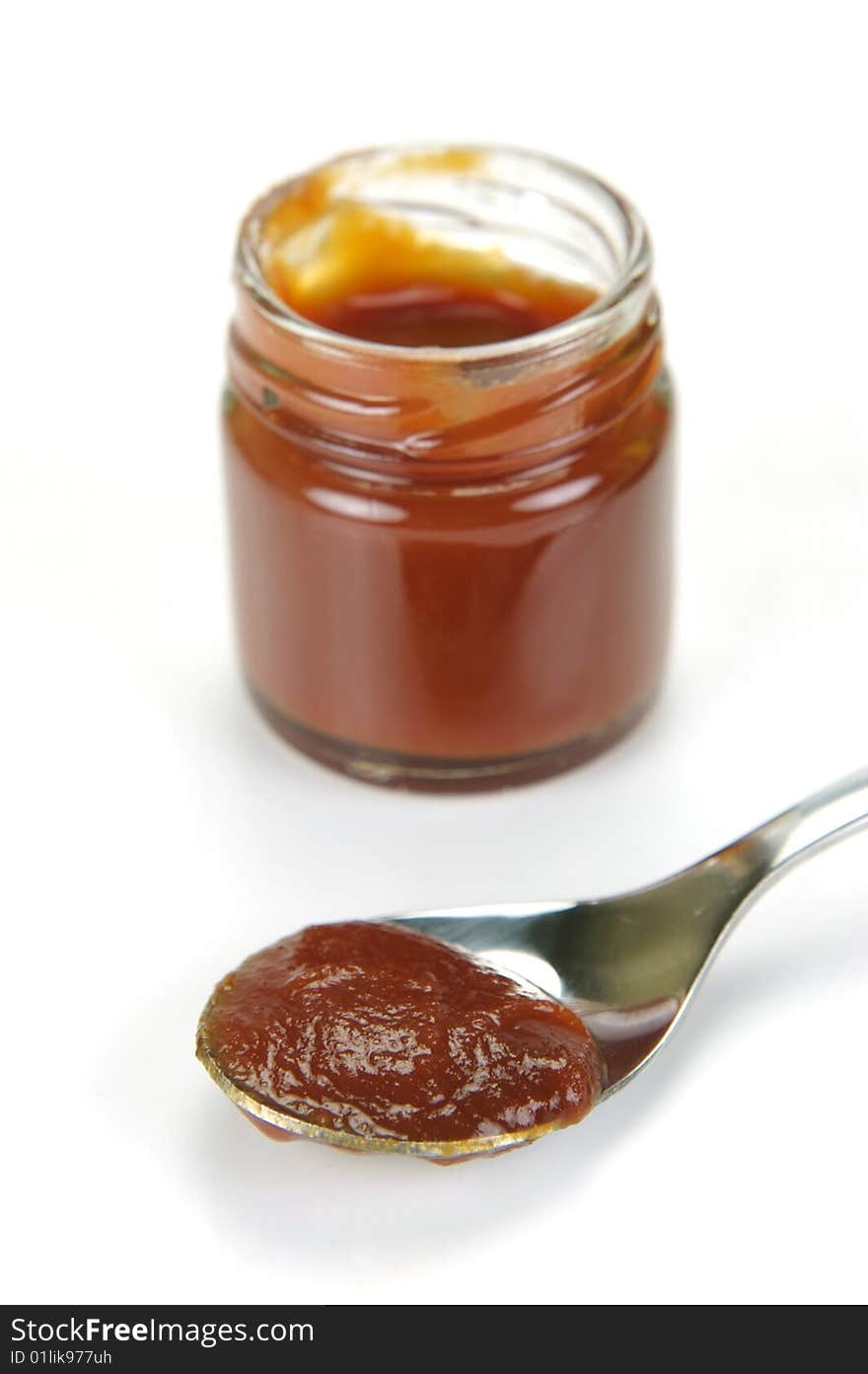 A small jar of ketchup isolated against a white background