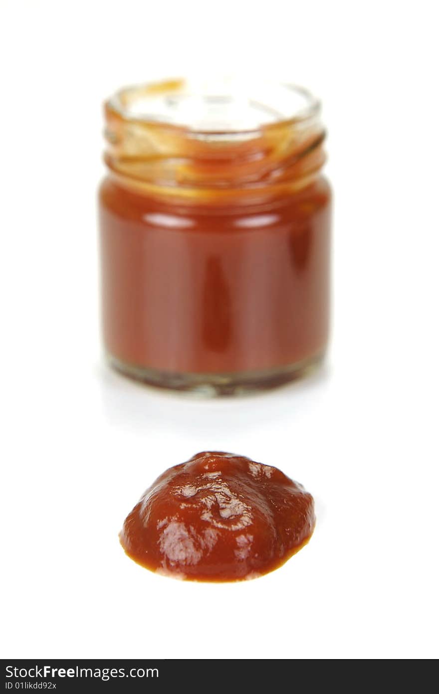 A small jar of ketchup isolated against a white background