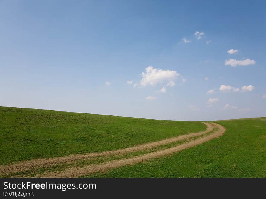 Narrow country road in a rural area on field