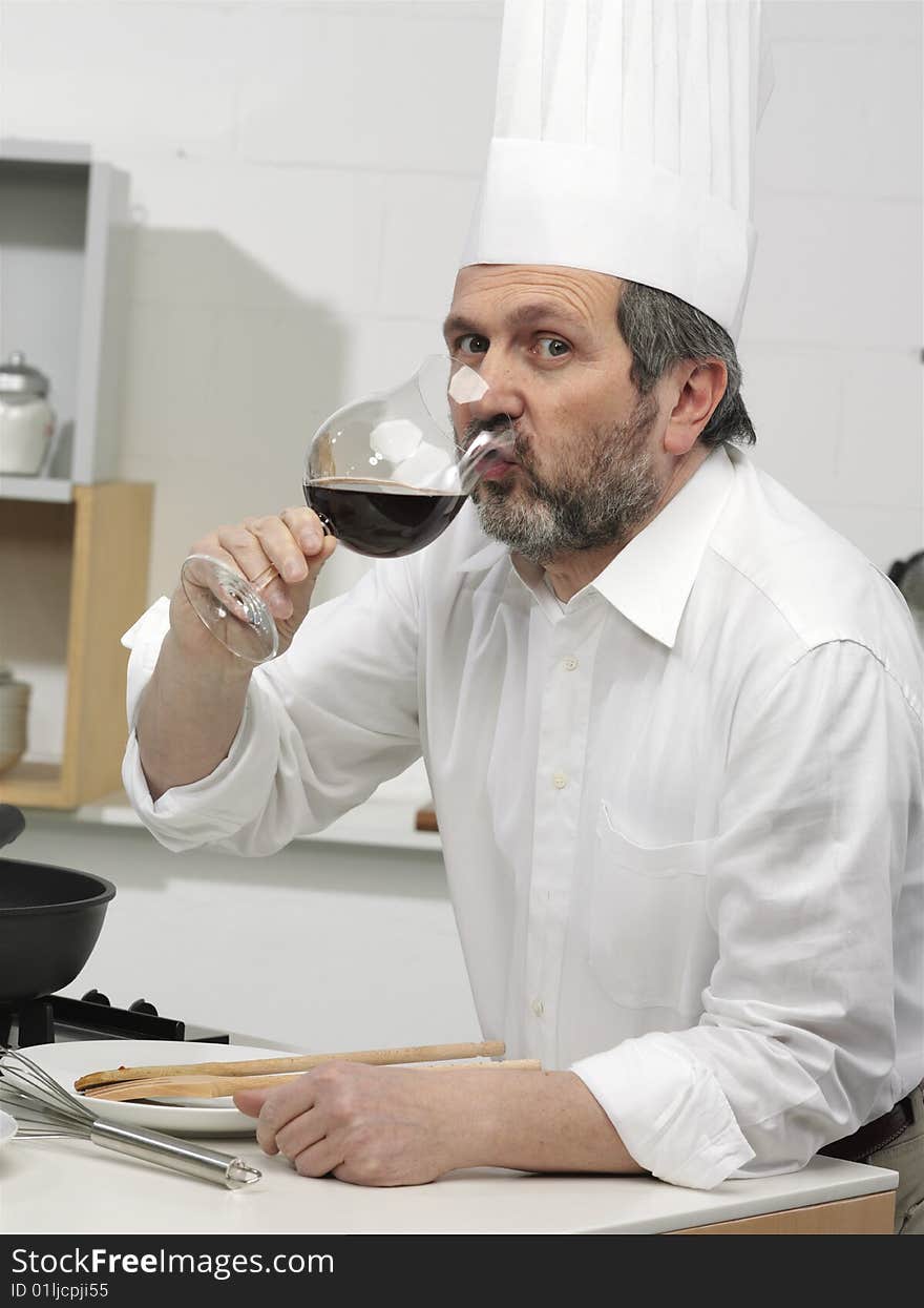 Cook in the kitchen with glass of wine