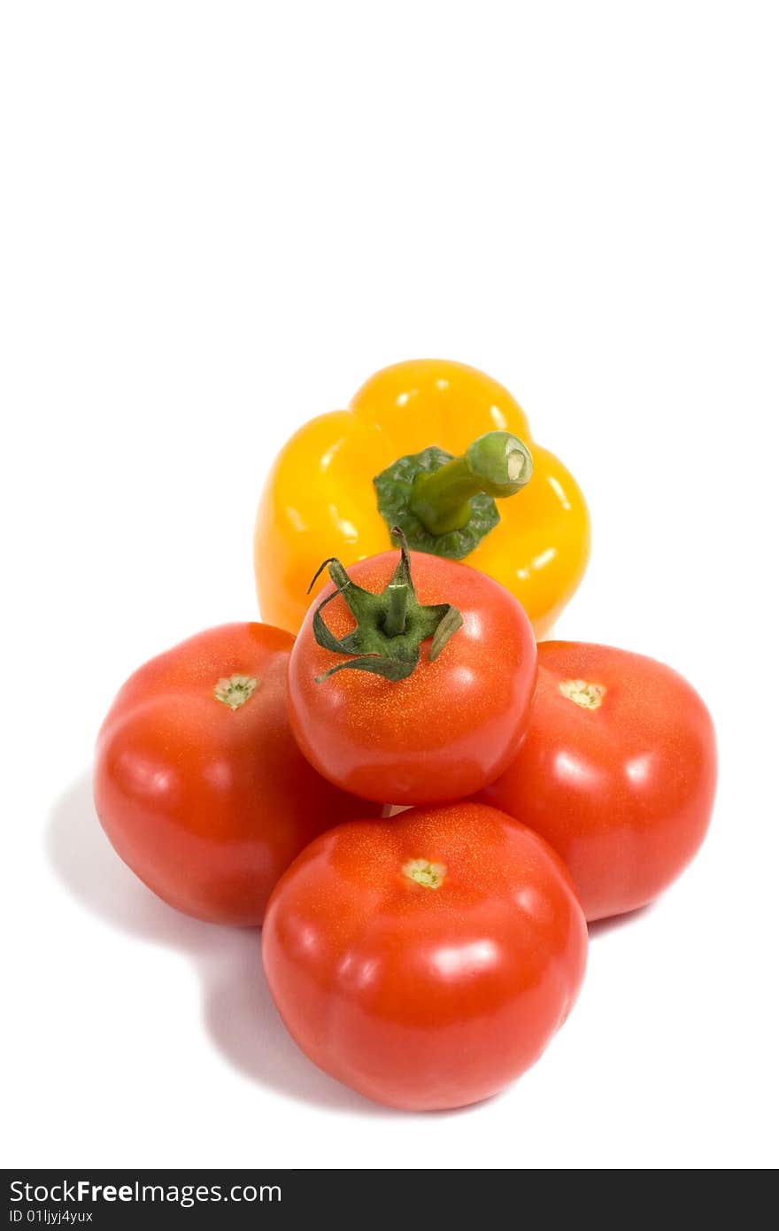 A group of vegetables composing of three red tomatoes and a yellow pepper isolated on white background. A group of vegetables composing of three red tomatoes and a yellow pepper isolated on white background