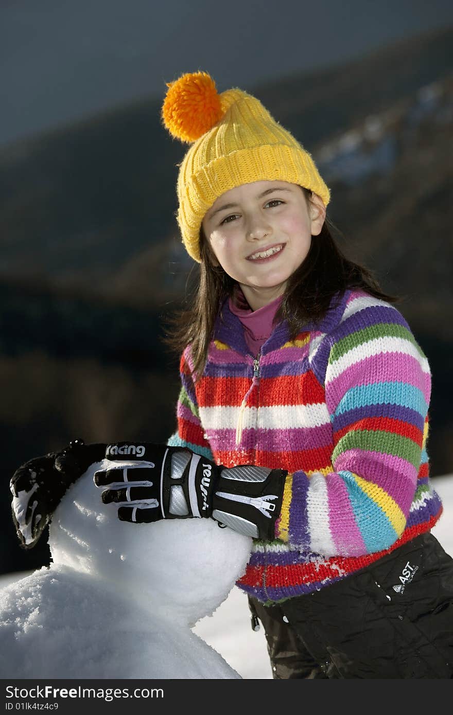 A cute young girl posing with her snowman