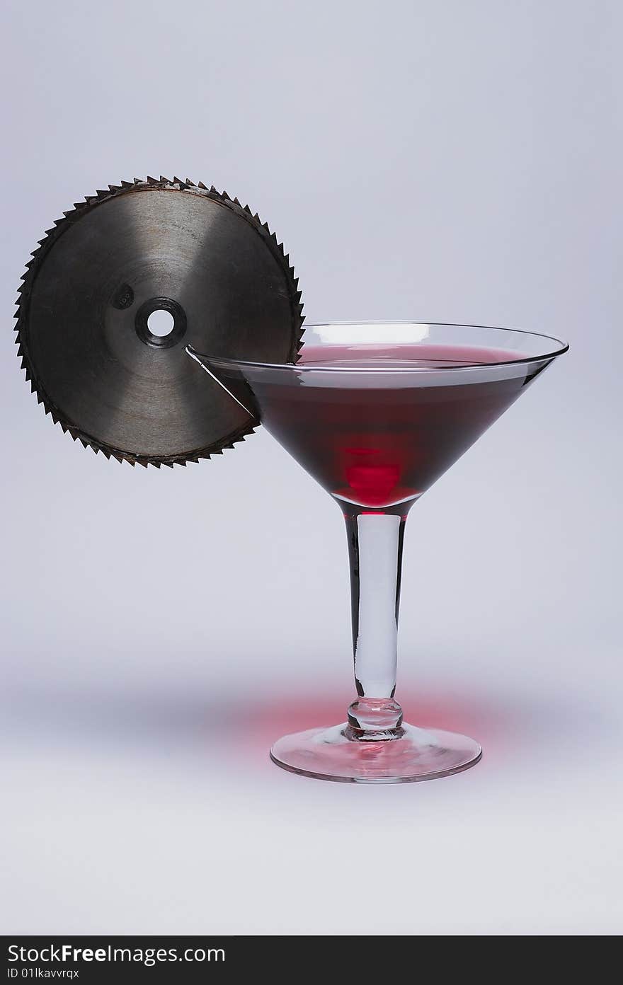 Oversize martini glass with sawblade garnish. Oversize martini glass with sawblade garnish