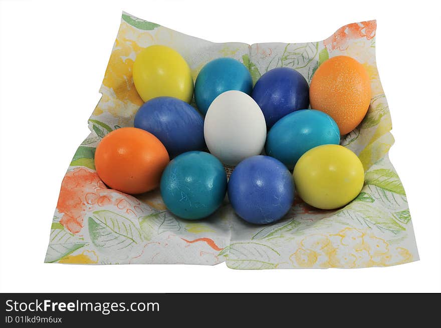 Multi-coloured Easter eggs lay on a napkin of a spring ornament