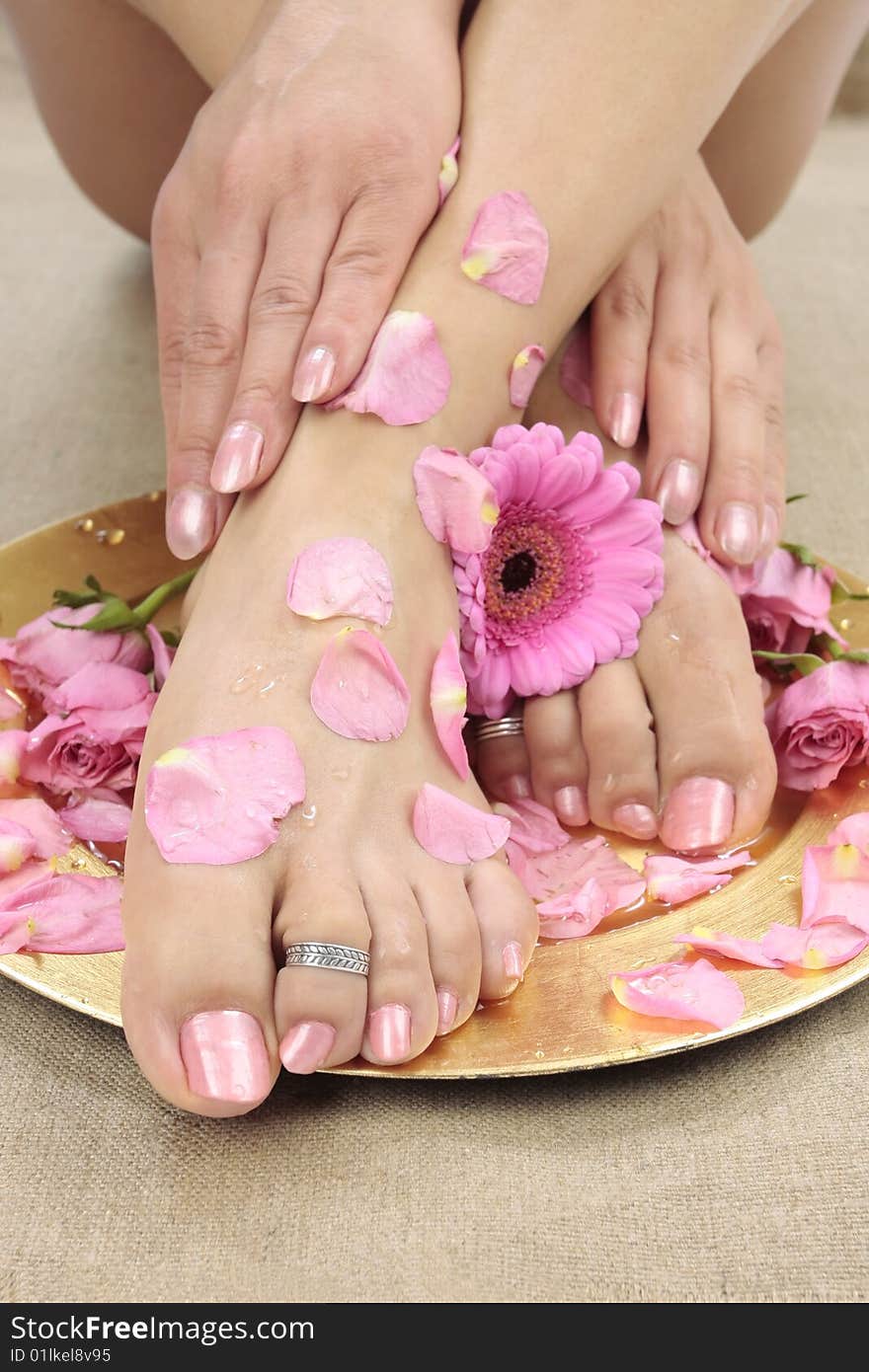 Beautiful woman  feet with flowers and petals