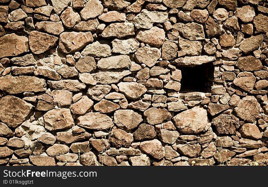 Old stone wall illuminated by the sun light.