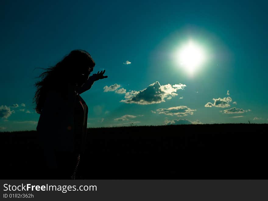 Silhouette of a girl reaching out to the sun