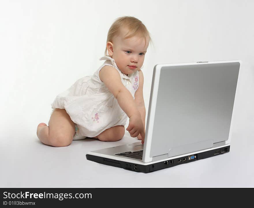 Little girl pressing the button on the laptop