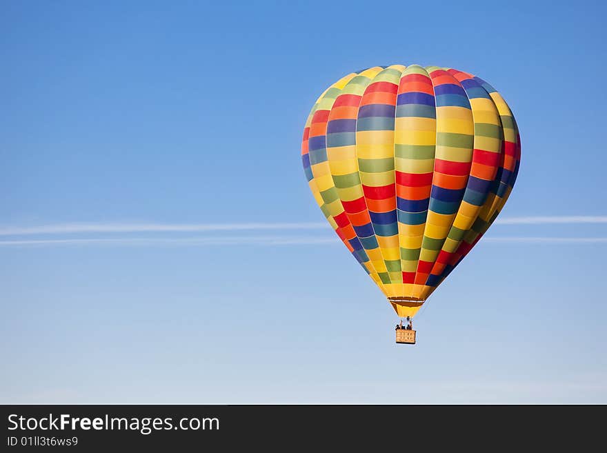 Unrecognizable people travelling in a multicolor balloon. Unrecognizable people travelling in a multicolor balloon