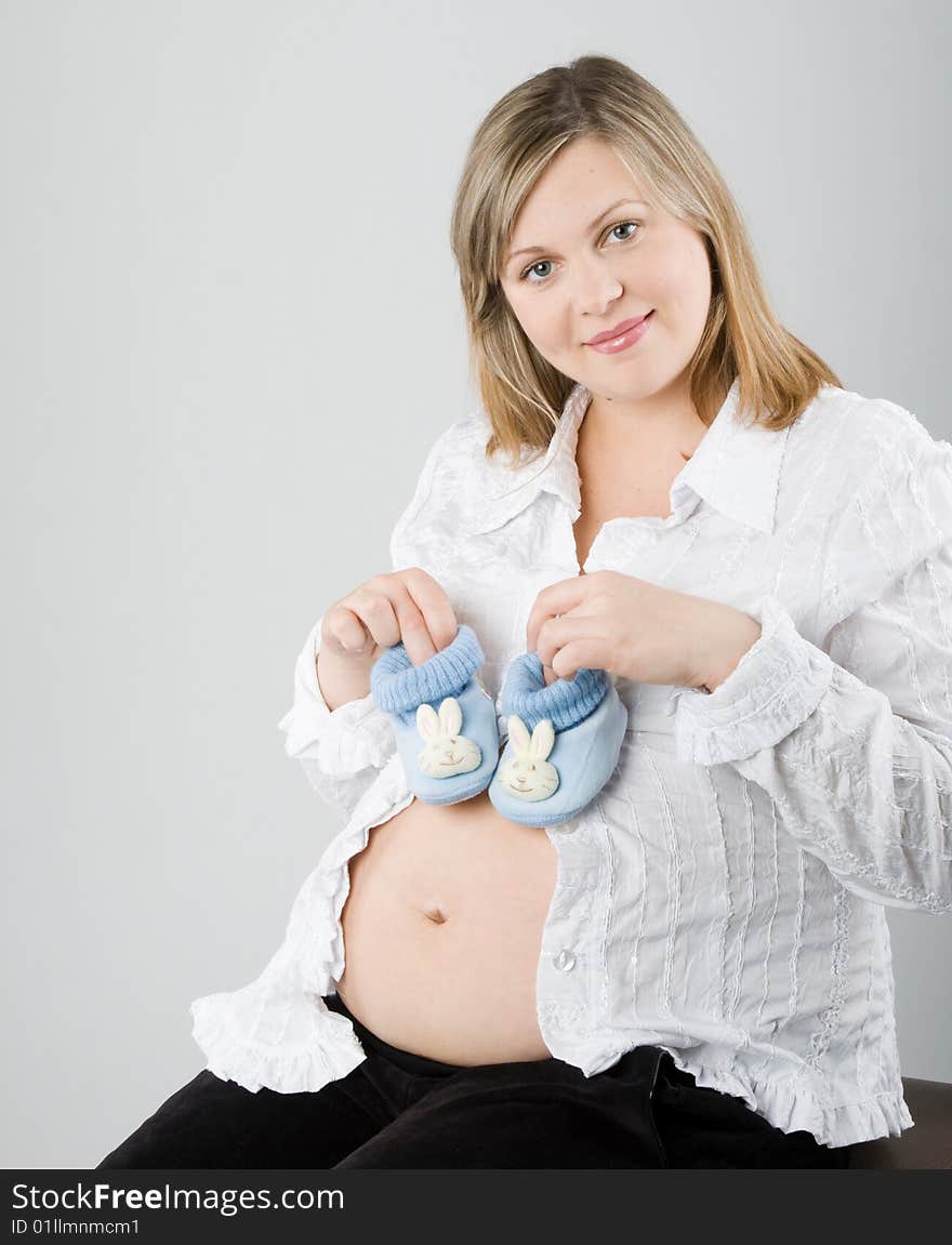 The pregnant woman on a gray background