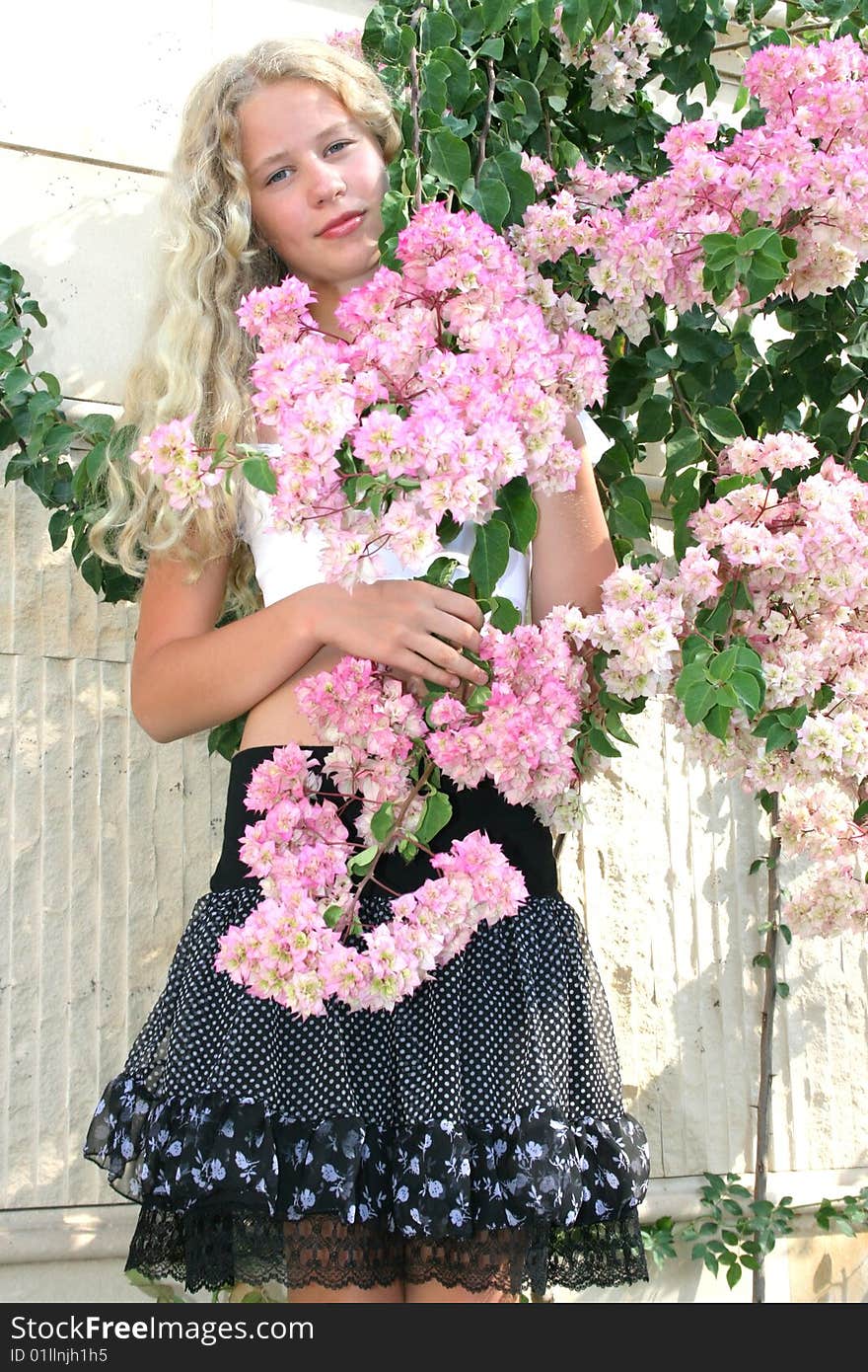 Pretty blond freckled girl with pink flowers. Pretty blond freckled girl with pink flowers.