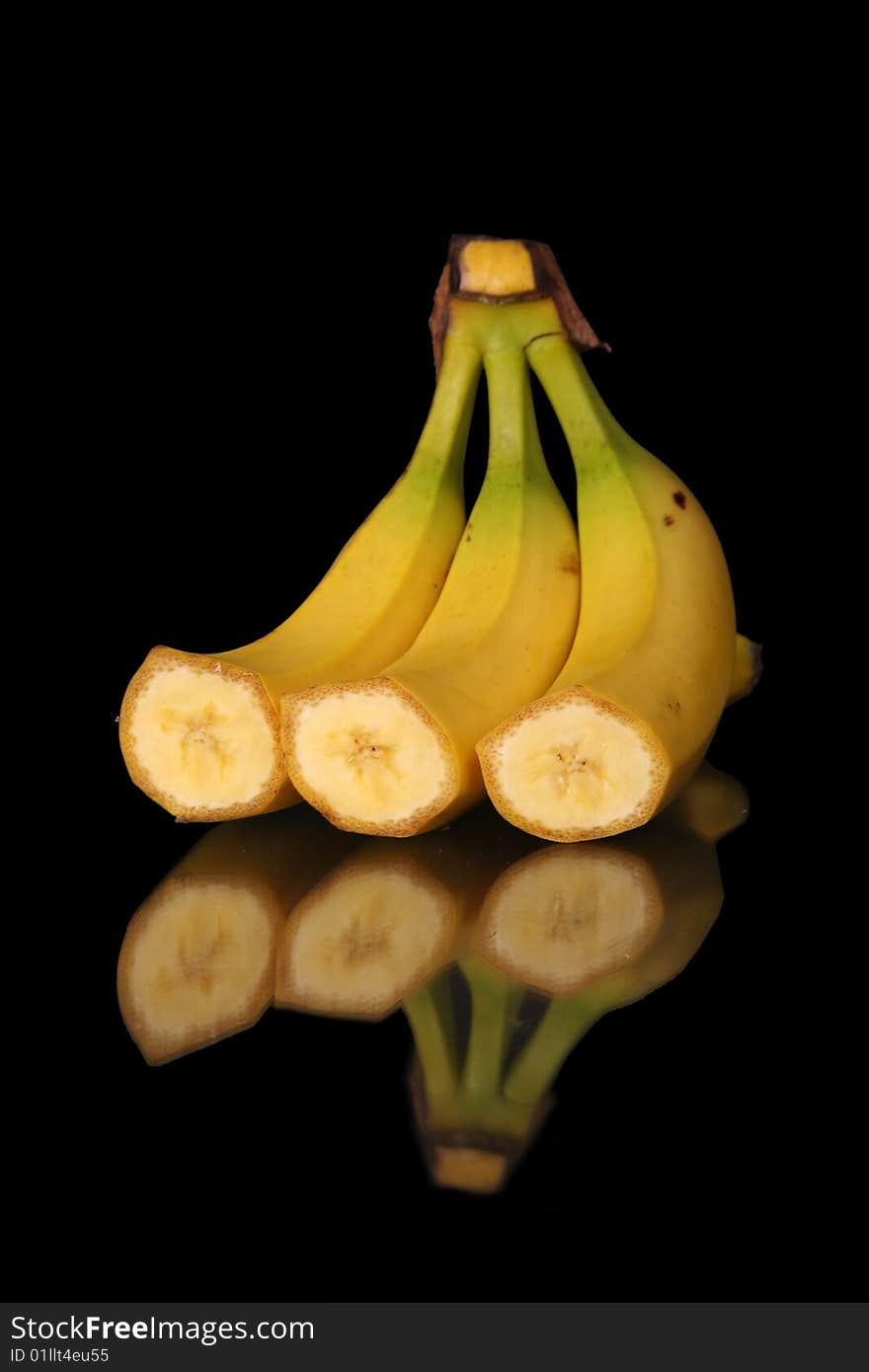 Mature cut bananas on black background