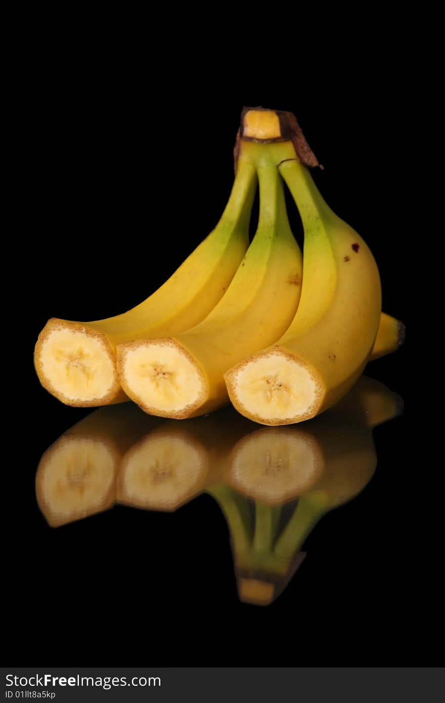 Mature cut bananas on black background