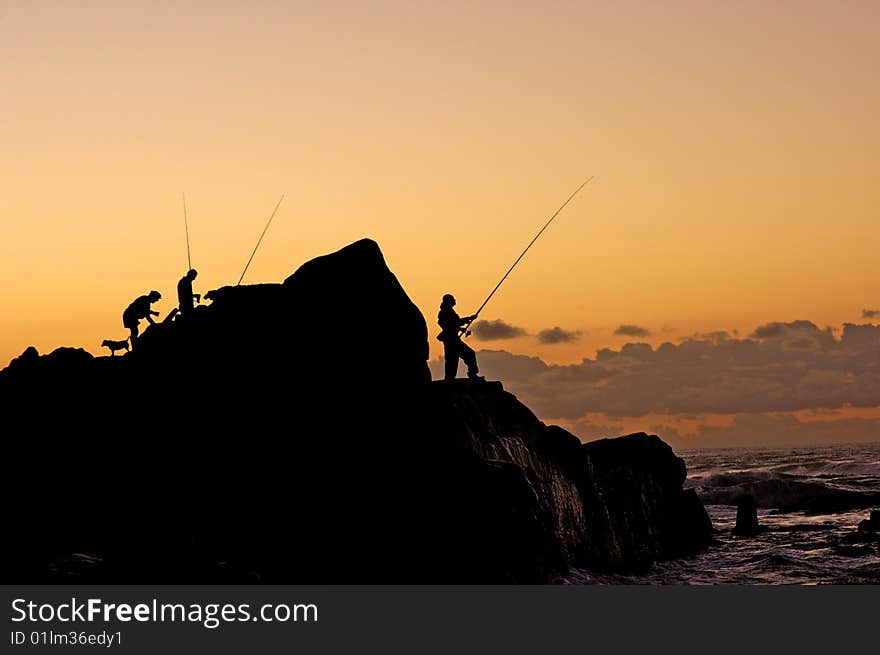 A silhouette of fishermen at dawn