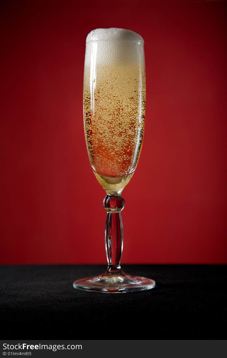 Champagne glass over red background