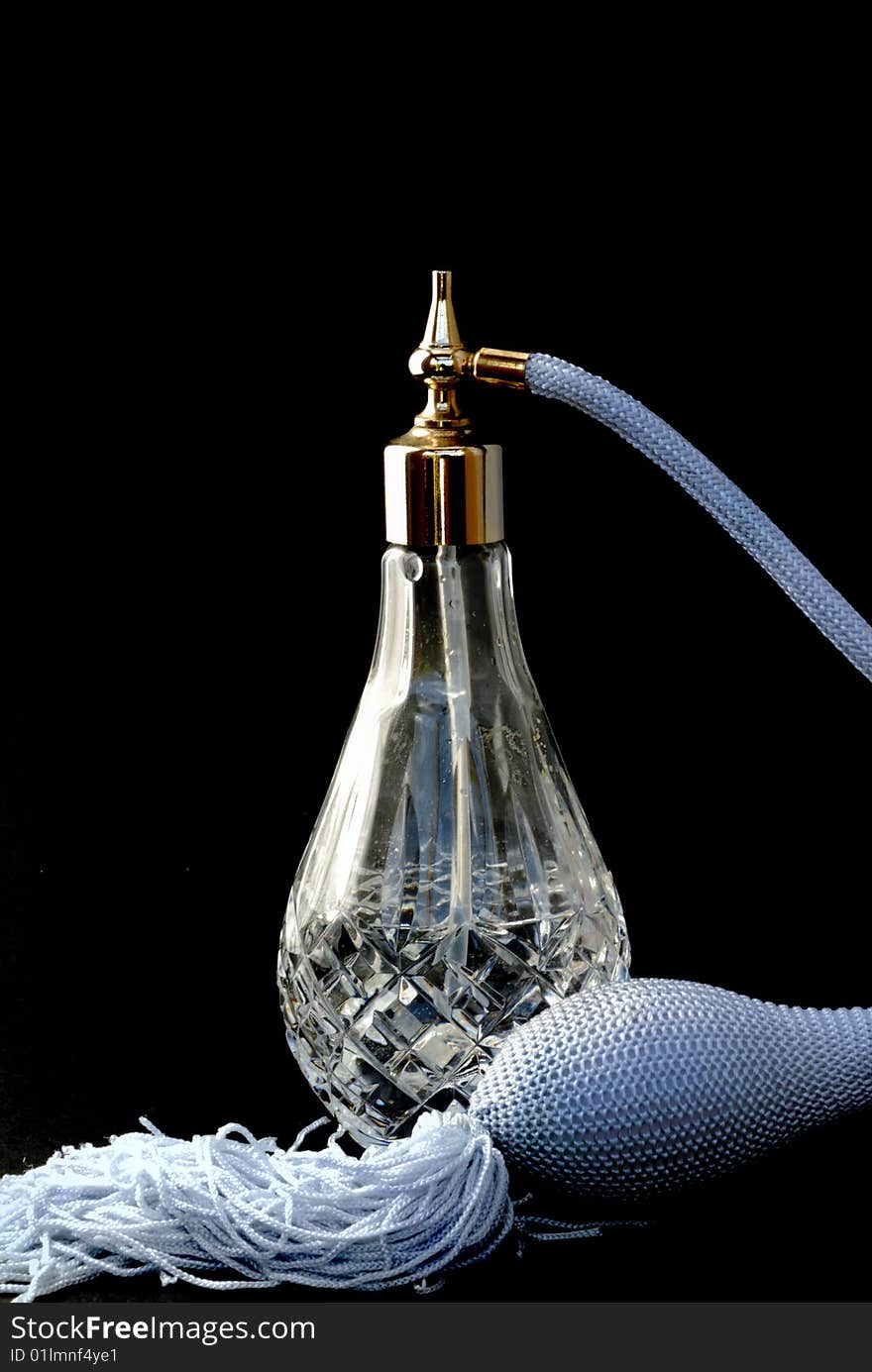 An elegant perfume atomizer on a black background. An elegant perfume atomizer on a black background