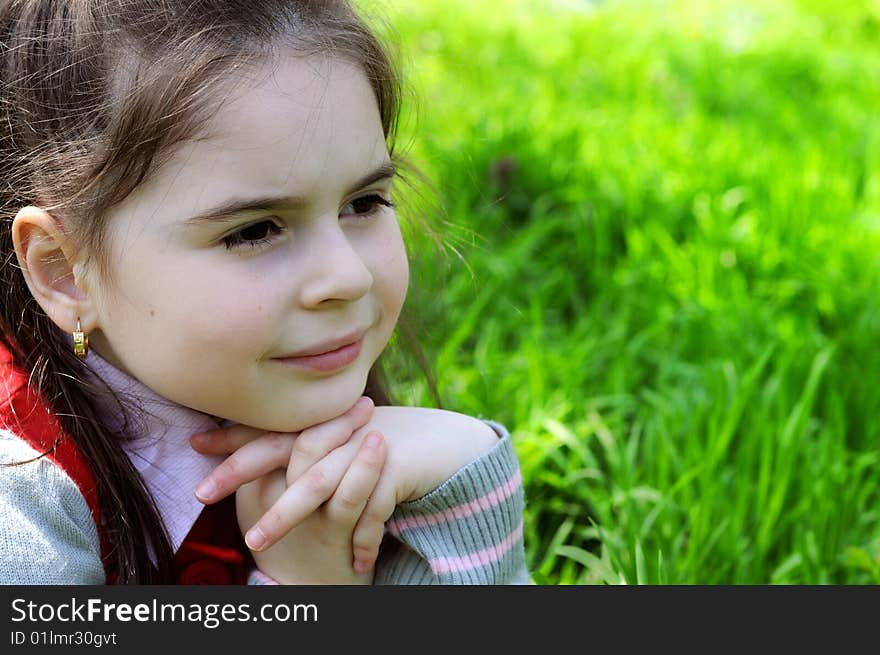 The girl sitting on a grass in park. The girl sitting on a grass in park