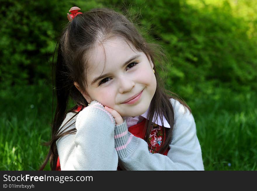 The girl sitting on a grass in park. The girl sitting on a grass in park