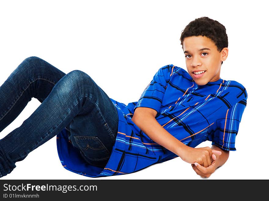 Teenage boy reclining on the floor isolated over white. Teenage boy reclining on the floor isolated over white