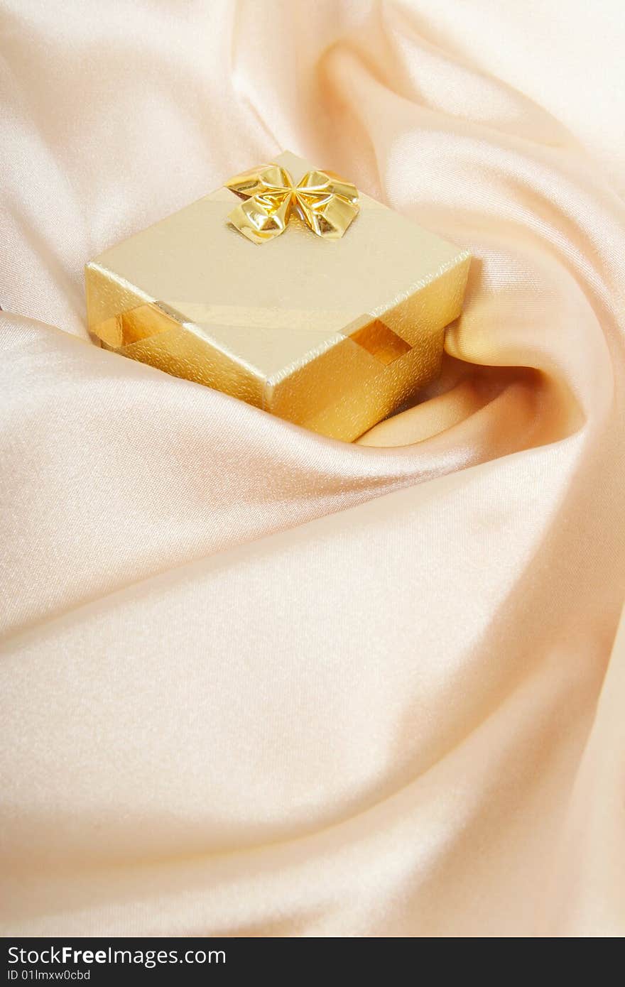 Golden gift box on silk background. Golden gift box on silk background