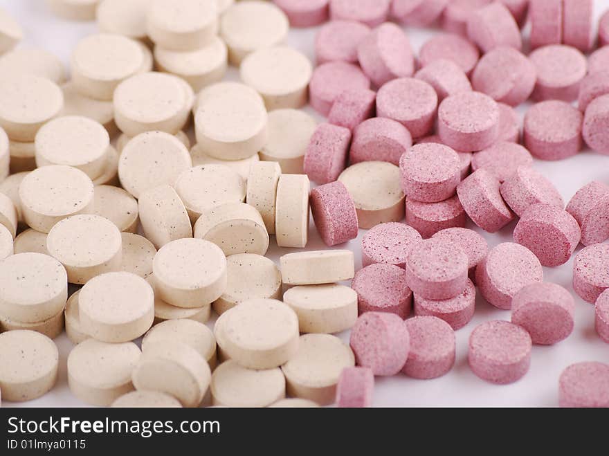 Tablets of various colour on a white background. Food additives.