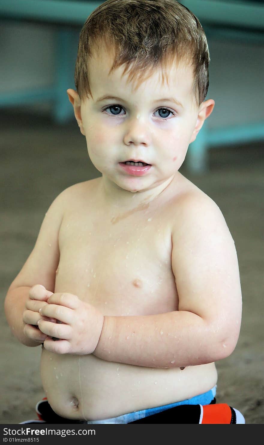 Little boy sitting on the side of the pool wet from swimming. Little boy sitting on the side of the pool wet from swimming