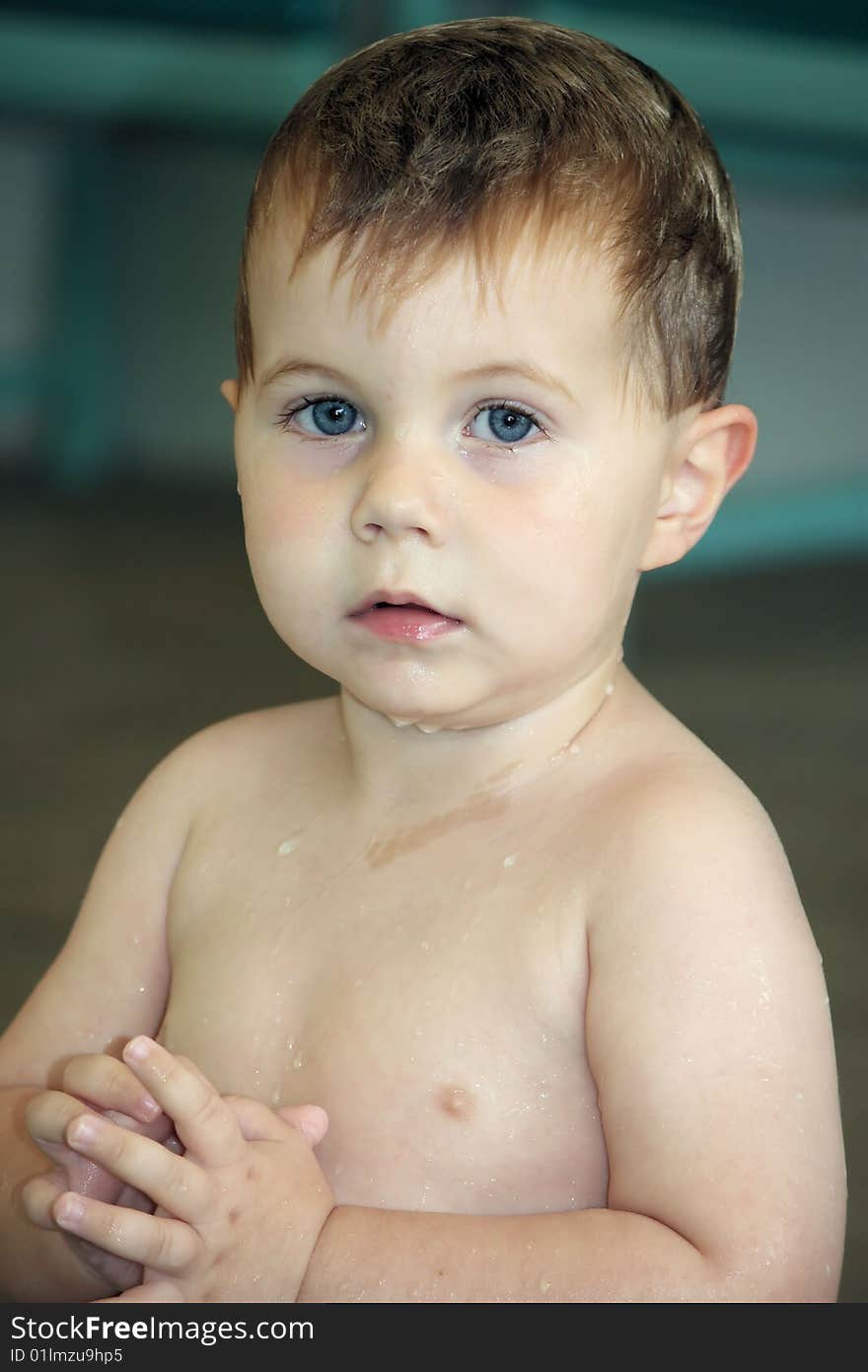 Little boy sitting on the side of the pool wet from swimming. Little boy sitting on the side of the pool wet from swimming