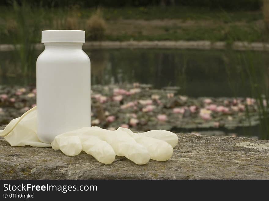 A white box on the rock. The white surface waiting for your product label. Water lily in the background.