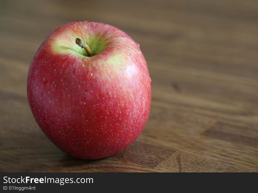 A red apple on a wooden surface