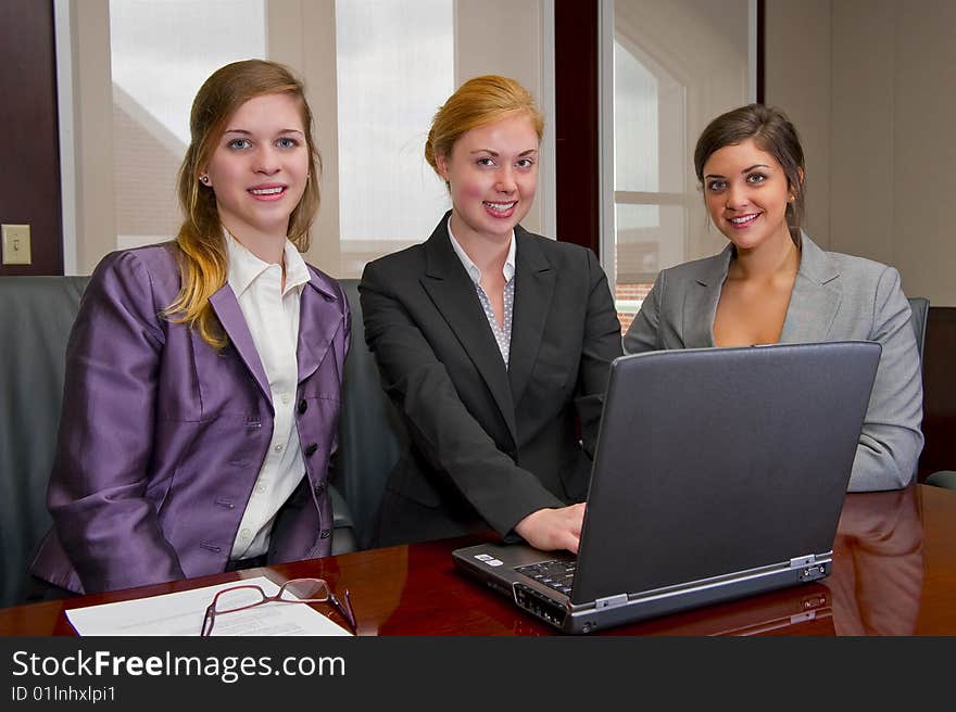 Women looking at a laptop working together. Women looking at a laptop working together