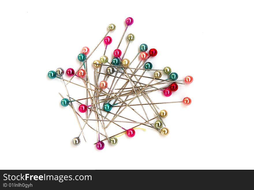 Heap of multi-coloured sewing pins on a white background