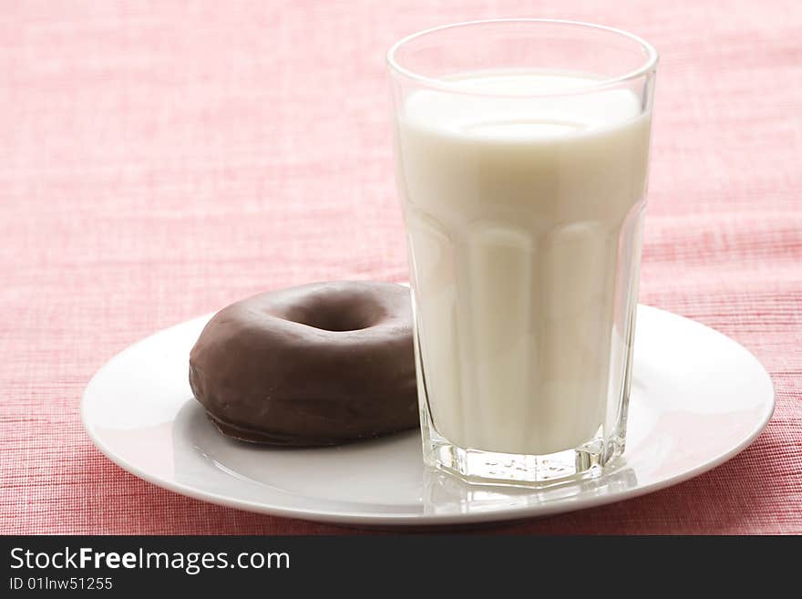 Breakfast glass of chocolate milk and donut isolated