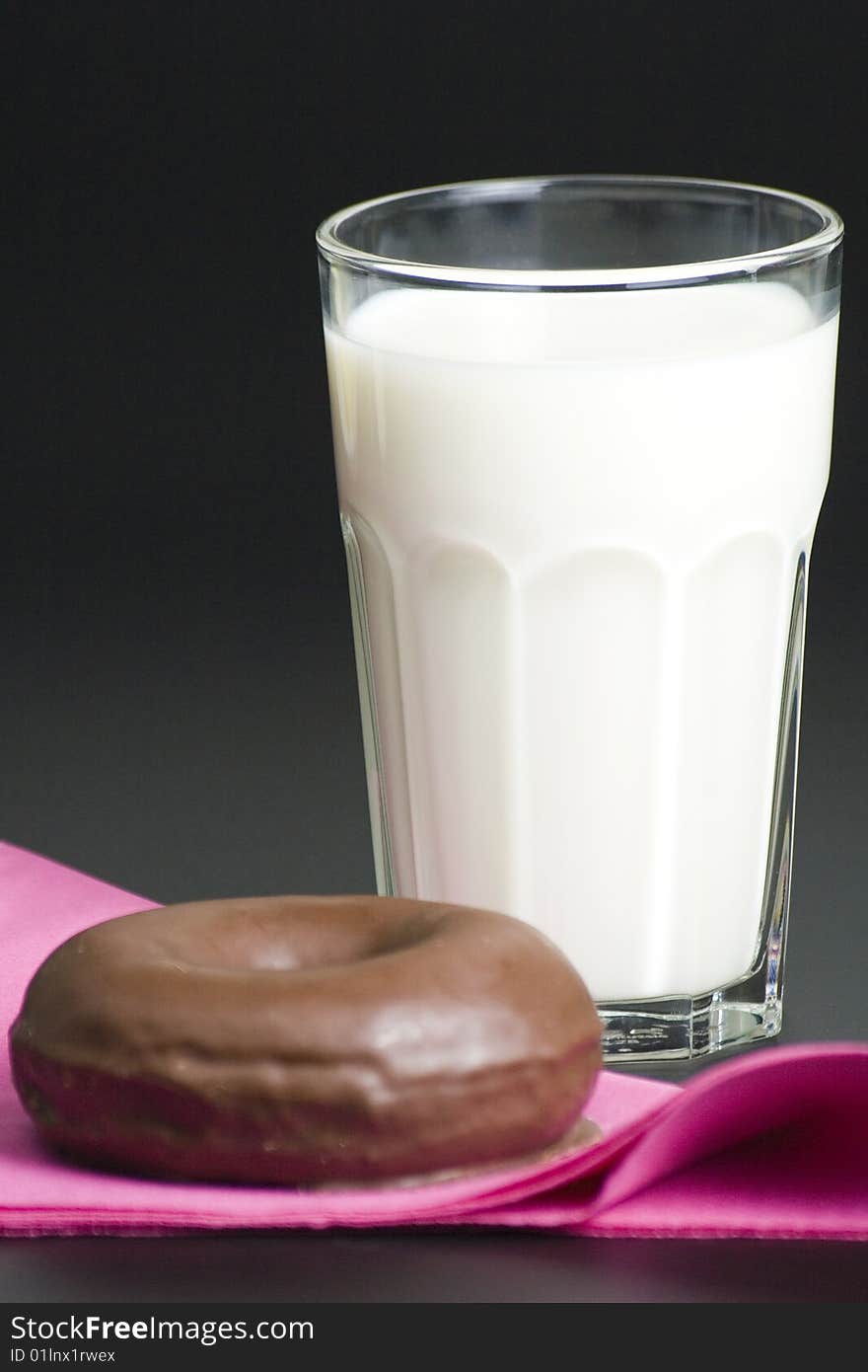 Breakfast glass of chocolate milk and donut isolated