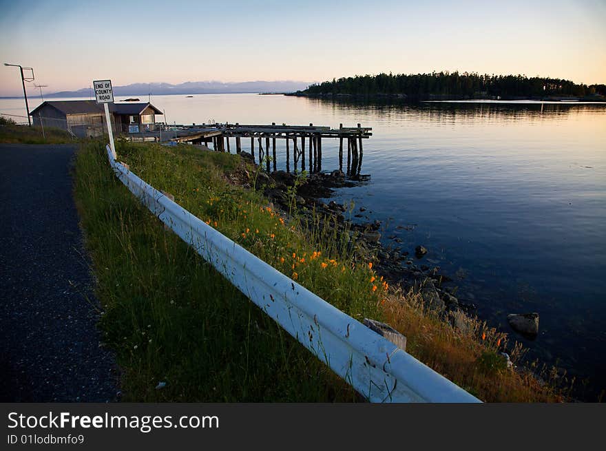 A dead end road on Lopez Island offers a vista of beautiful sunset colors with the Olympic Mountains in the background. A dead end road on Lopez Island offers a vista of beautiful sunset colors with the Olympic Mountains in the background.