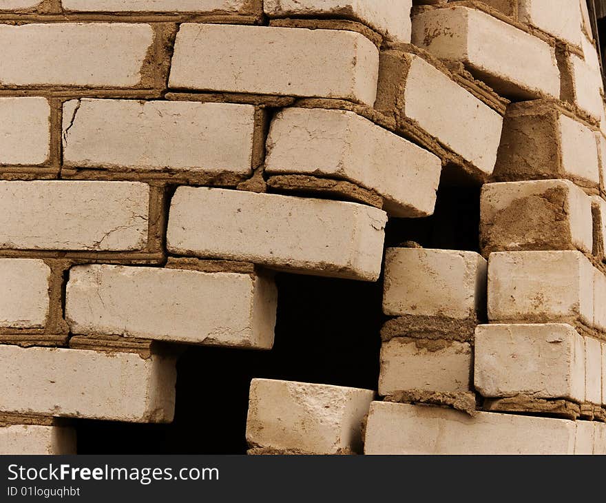 Destruction of a wall of the house from a brick abstract background