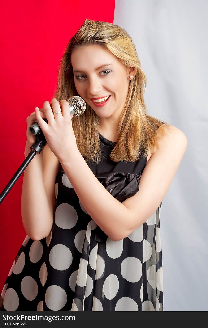 Young blonde girl with microphone smiling. Young blonde girl with microphone smiling