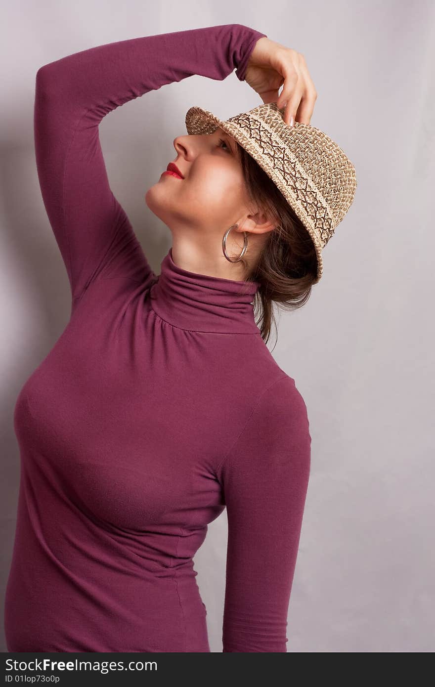 Girl in bright hat standing half-face smiling turned