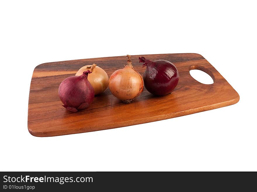 Two brown and two purple onions on brown cutting board. Isolated on white. Two brown and two purple onions on brown cutting board. Isolated on white.