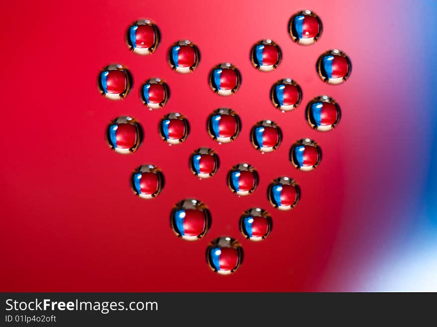 Water drops in the form of heart on a celebratory background