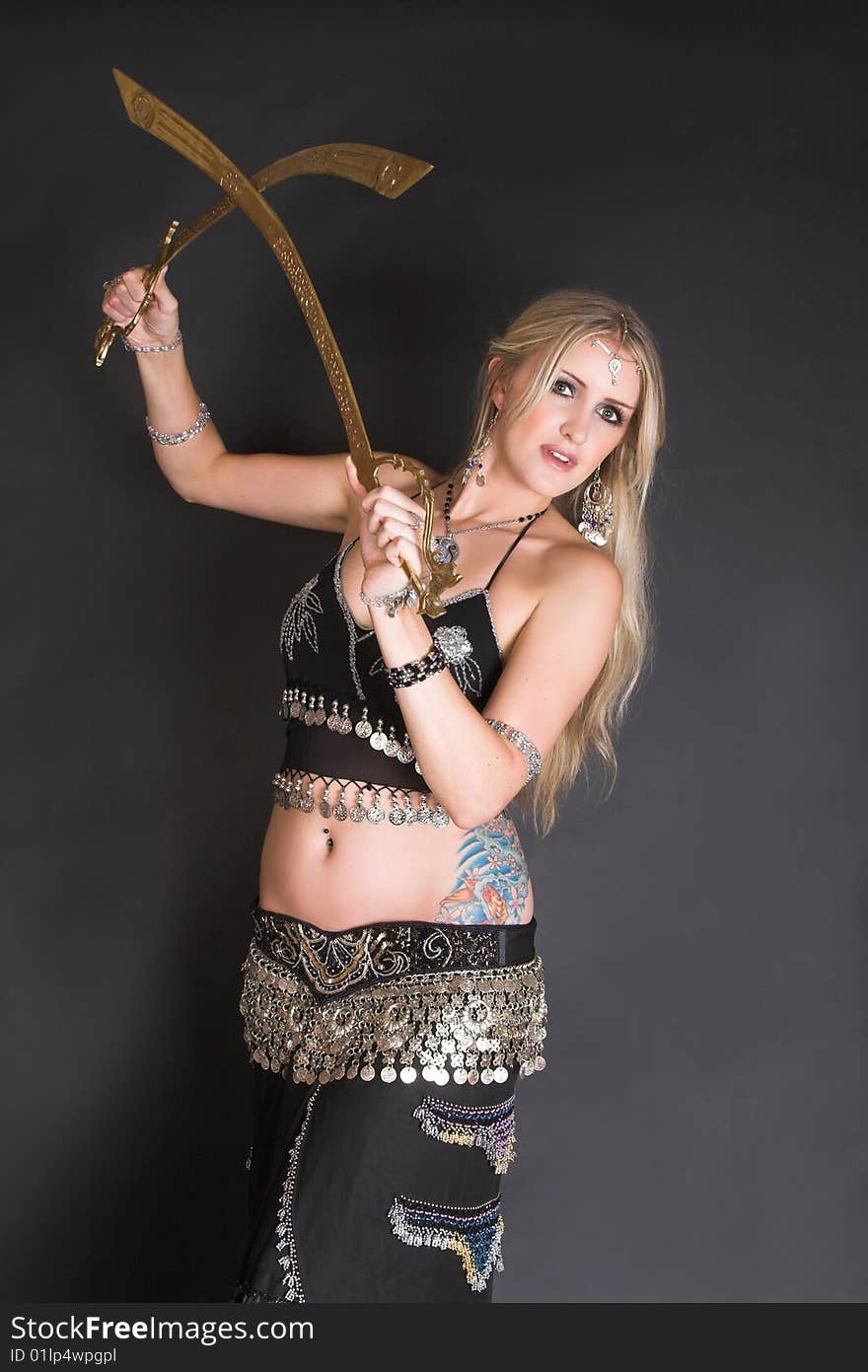 Beautiful Blond Belly Dancer with bronzed tribal swords